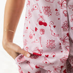 Close-up of the bb&b Sleep XOXO PJ Set in Pink, highlighting the red cherries, hearts, love letters and tic-tac-toe print.