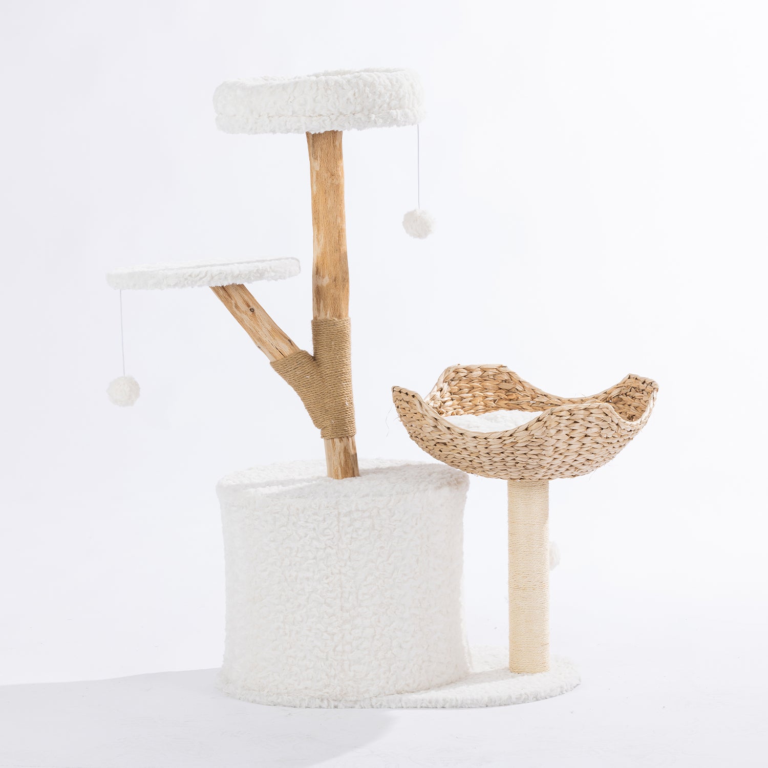Rear view of the cream cat tower showing the plush hideaway, woven basket bed, elevated perch, natural wood-look scratching post, and dangling pom-pom toys.