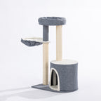 Angled view of the grey and cream cat tower featuring a plush hideaway, elevated round bed, suspended hammock, and sisal-wrapped scratching posts.