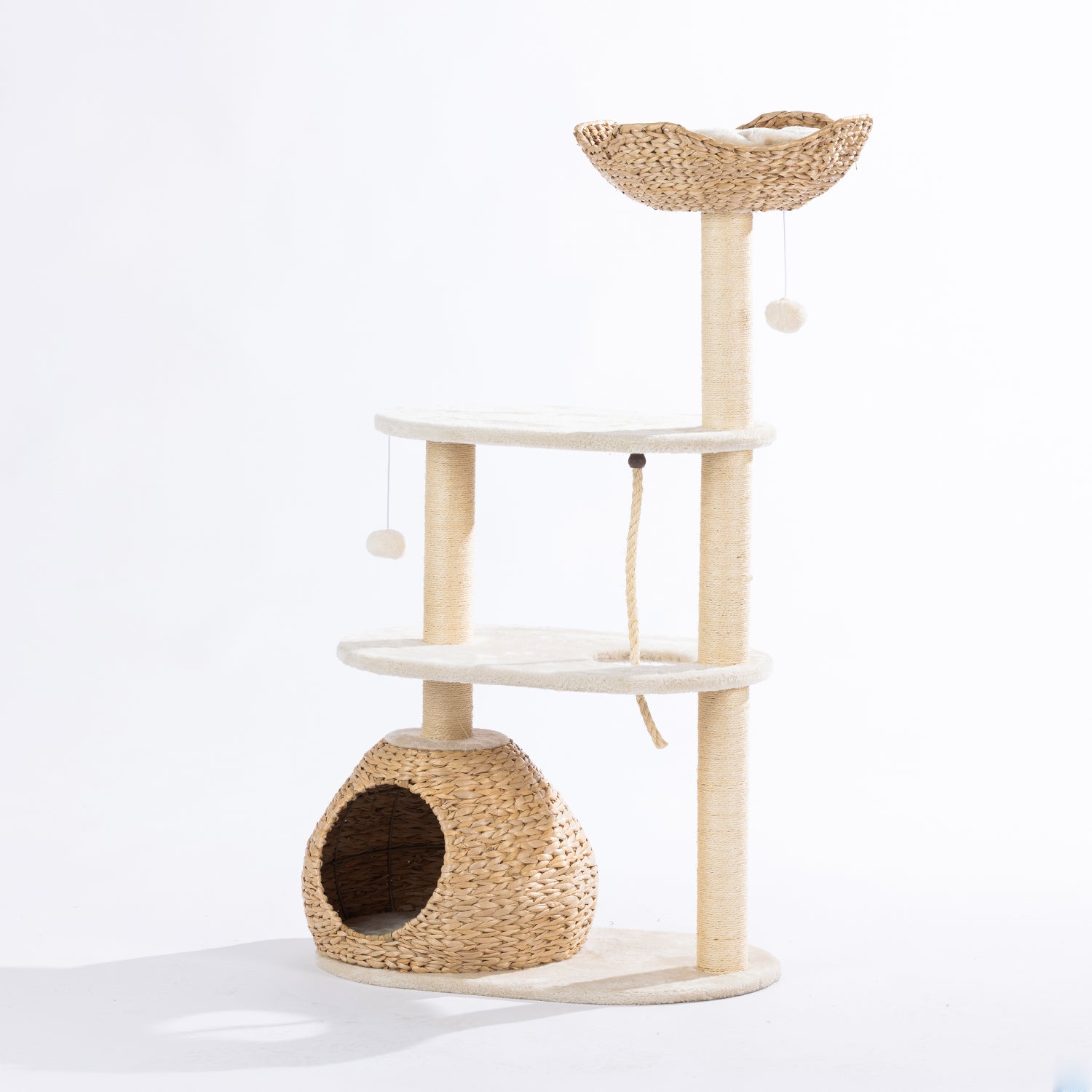 Angled front view of the natural woven cat tower featuring the plush top basket, woven hideaway, sisal scratching posts, climbing rope, and hanging pom-pom toys displayed on a white background.