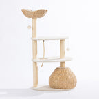Rear view of the natural woven cat tower showing the woven hideaway, plush platforms, sisal scratching posts, climbing rope, and hanging pom-pom toys on a white background.