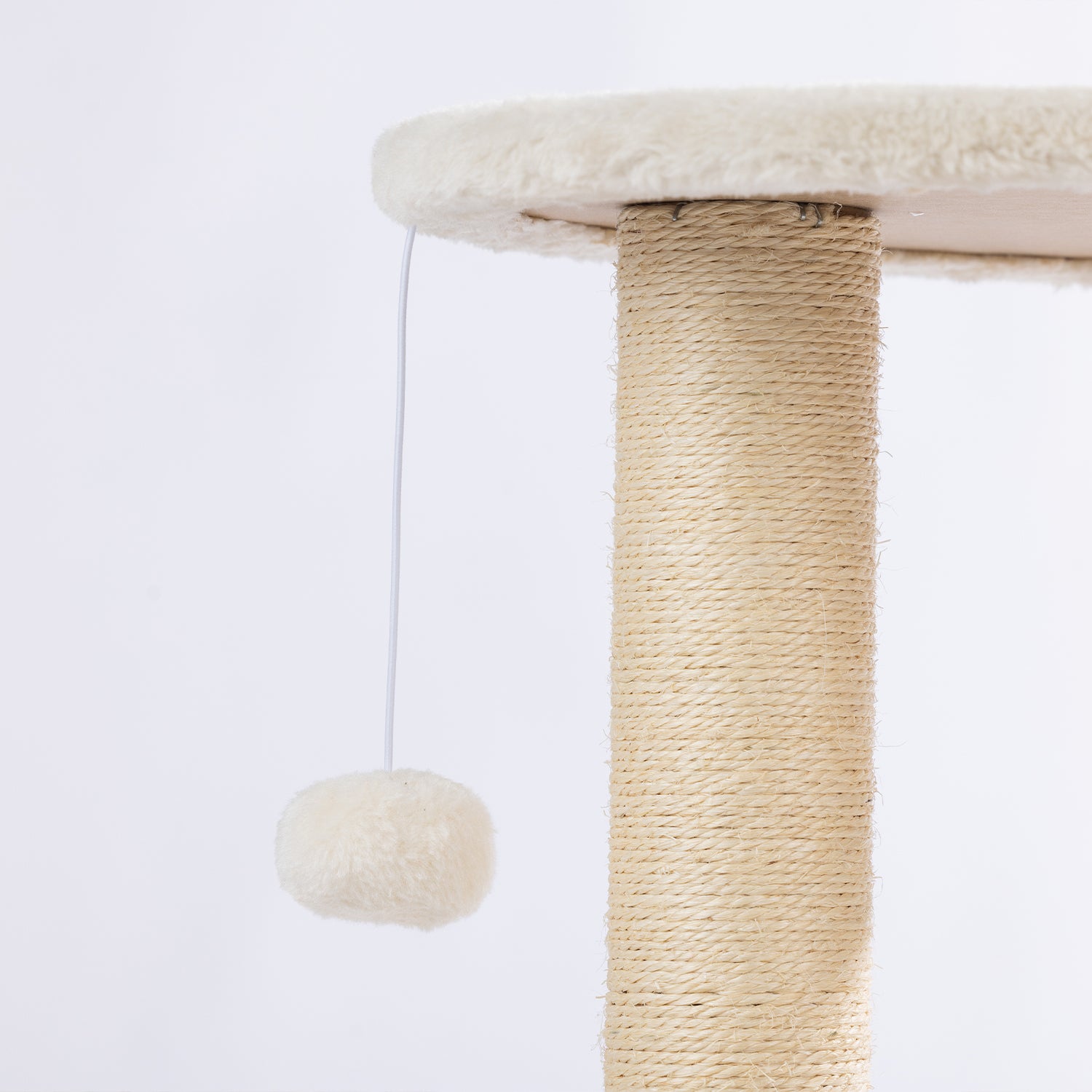 Close-up of the plush hanging pom-pom toy attached beneath the upper platform of the natural woven cat tower.