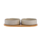 Two mushroom-coloured ceramic pet bowls displayed on a natural bamboo holder.