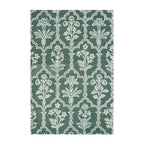 Forest green wool rug featuring an elegant repeating floral and trellis pattern in ivory, creating a classic, decorative design.
