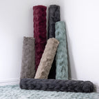 A collection of rolled faux fur rugs in a range of contemporary colours showcases their luxuriously soft texture and plush finish, perfect for adding warmth and style to any home.