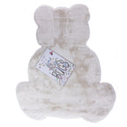 A plush ivory faux fur rug in the shape of a seated teddy bear, featuring a luxuriously soft texture and a playful silhouette perfect for a nursery or children's bedroom.