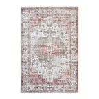 A rectangular vintage-style area rug with a distressed traditional pattern in soft pink, beige, and gray tones, shown flat against a white background.