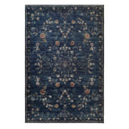 A rectangular area rug with a distressed navy blue background and an intricate vintage-style floral pattern in muted beige, rust, and white tones.
