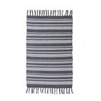 Home Co. Amelia Scatter Charcoal Stripe Rug featuring a woven charcoal and natural striped design with tasselled ends.