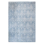 A soft blue textured rug featuring an all-over ornate floral damask pattern in white with a delicate decorative border against a white background.
