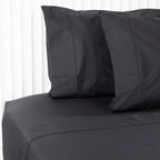Black bed flat sheets and pillows on a white background