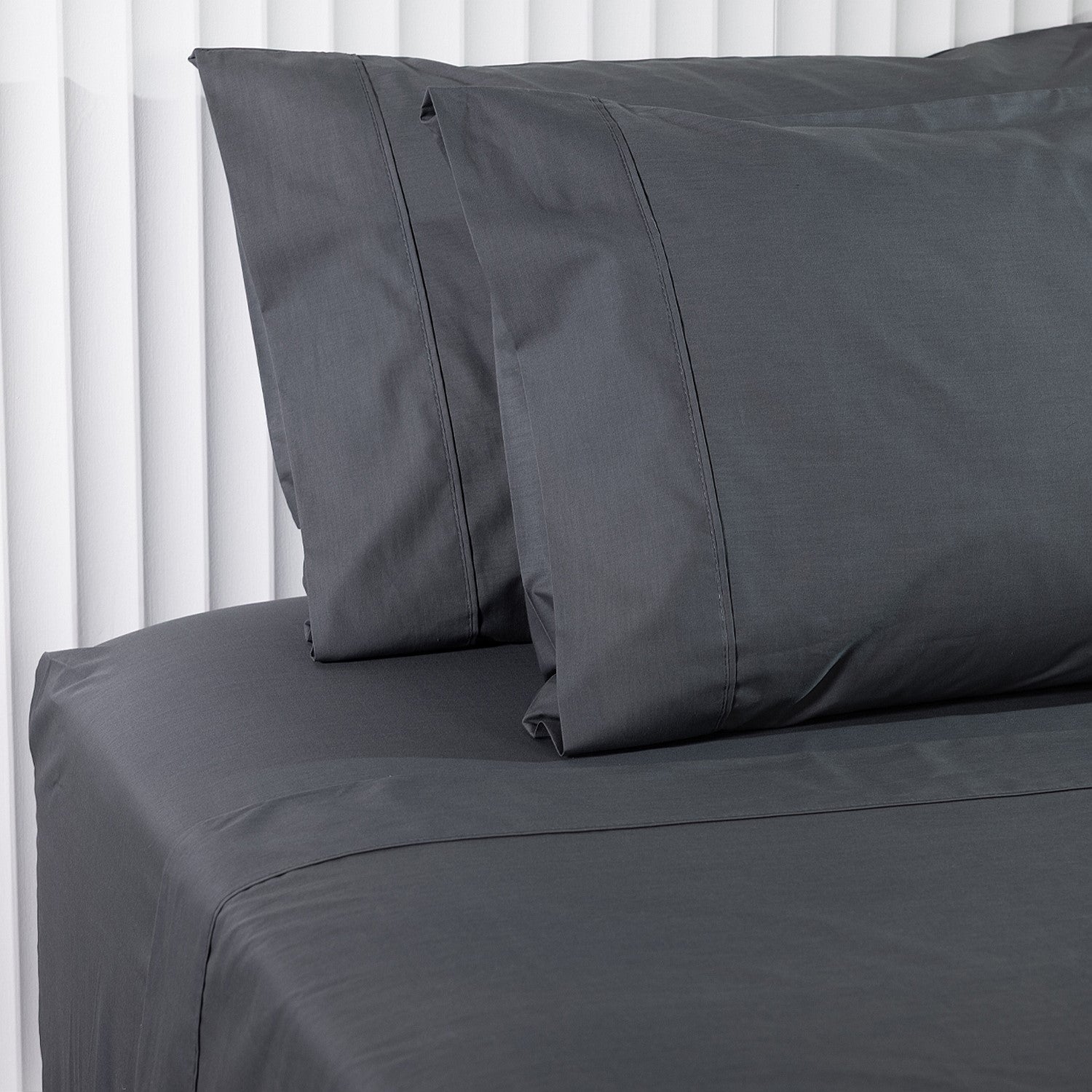 Gray bed sheets and pillowcases on a white background