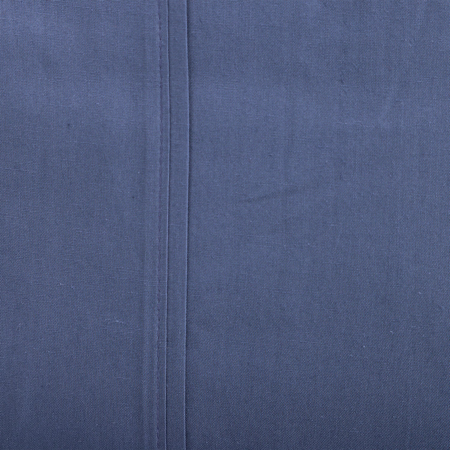 Close-up of a blue fabric with a seam running vertically.