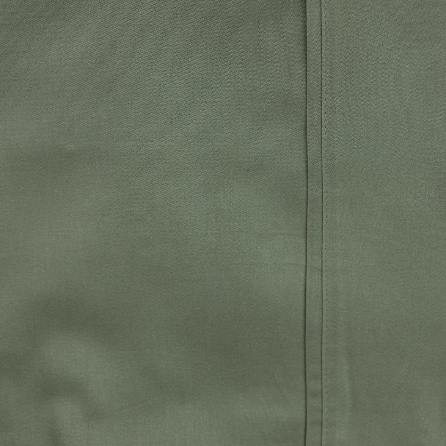 Close-up of smooth olive cotton sheet fabric and stitched hem detail.