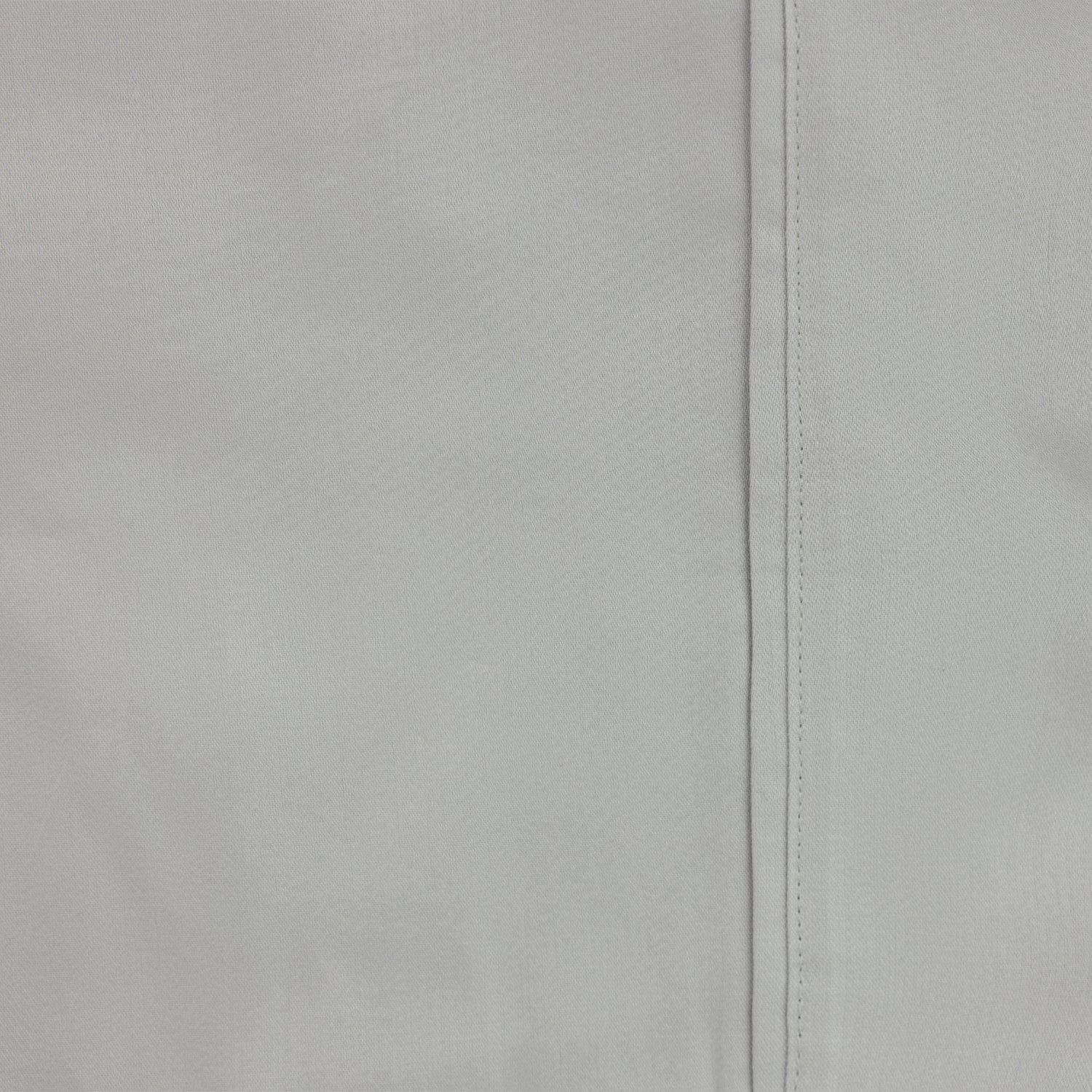 Close-up of smooth silver cotton sheet fabric and stitched hem detail.