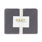 A beautifully packaged white 1000 thread count cotton sheet set is elegantly presented with a reusable storage band and premium branded sleeve, reflecting timeless luxury.