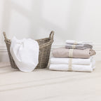 A stack of premium sheet sets in timeless neutral tones is neatly organised with reusable branded storage bands, bringing elegant style and effortless organisation to your linen cupboard.