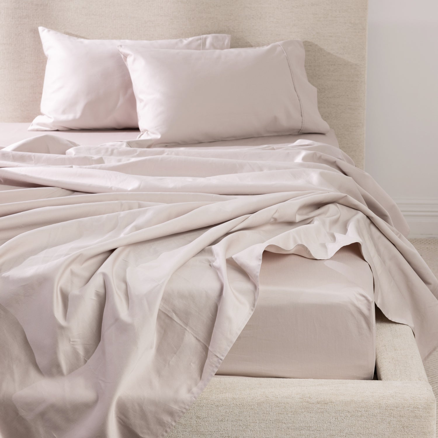 A luxurious linen sheet set is beautifully styled on a contemporary upholstered bed, showcasing its smooth, crisp finish and timeless elegance.