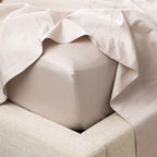 A close-up of a fitted sheet wrapped smoothly around the mattress highlights its crisp finish, tailored fit and luxurious sateen-like appearance.