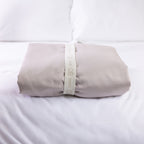 A neatly folded sheet is secured with a reusable branded storage band, showcasing elegant presentation and effortless linen organisation.