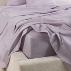 A close-up of the Gracious Living Avery Sheet Set in Dusky Mauve, featuring smooth cotton sateen sheets draped across a bed with matching pillowcases and a fitted sheet.