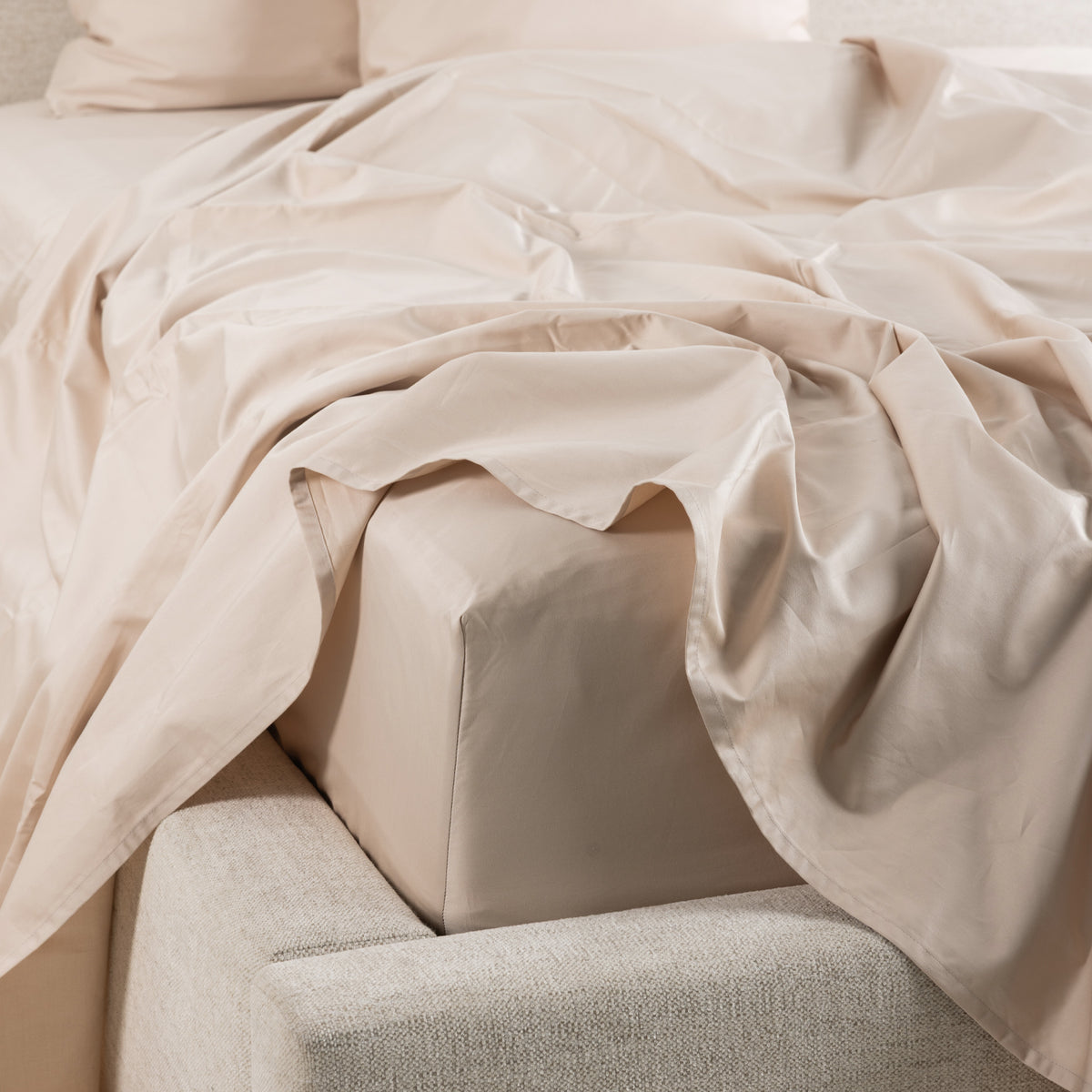 A close-up of the Gracious Living Avery Sheet Set in Taupe, featuring smooth cotton sateen sheets draped across a bed with matching pillowcases and a fitted sheet.