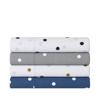 Stack of Pure & Simple Monroe Sheet Sets in assorted polka dot colourways, including white and black, grey and white, white and olive, and navy and white.