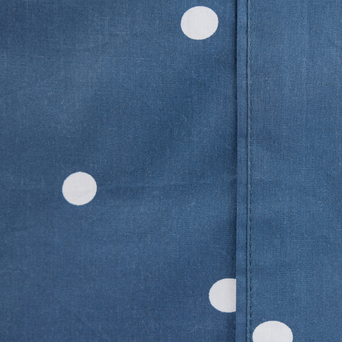 Close-up of the Pure & Simple Monroe Sheet Set in navy, showing the white polka dot pattern and stitched seam detail.