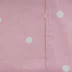 Close-up of the blush Monroe Sheet Set showing the soft pink fabric, white polka dot print and stitched seam detail.
