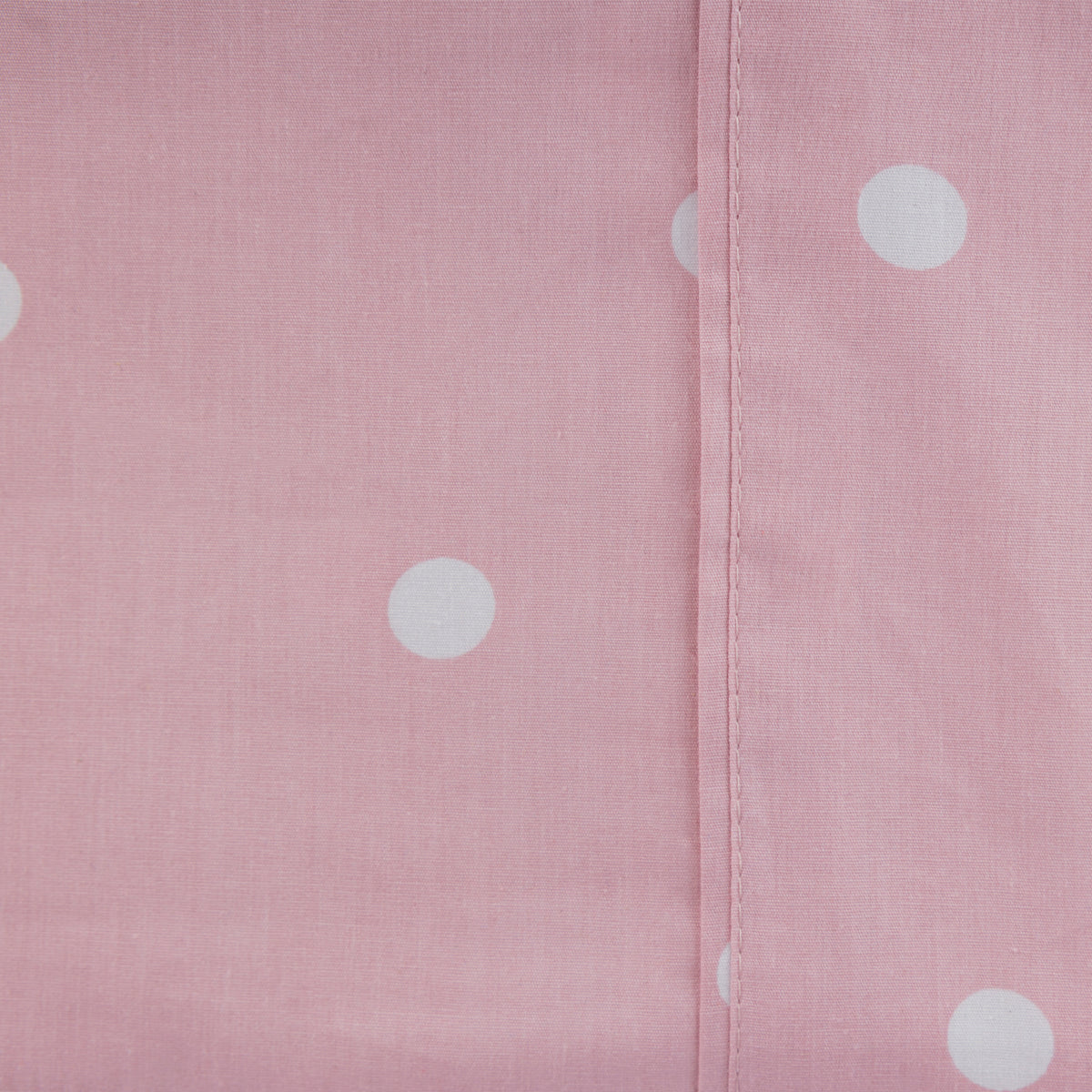 Close-up of the blush Monroe Sheet Set showing the soft pink fabric, white polka dot print and stitched seam detail.