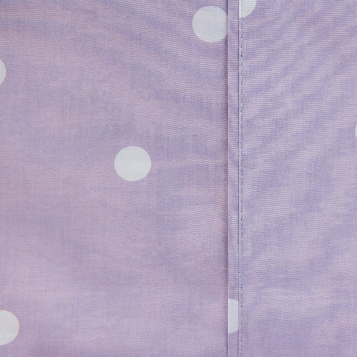 Close-up of the lilac Monroe Sheet Set showing the soft purple fabric, white polka dot print and stitched seam detail.