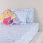 Mermaid Dreams fitted sheet set styled on a bed with matching printed pillowcases and a decorative mermaid cushion.