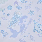 Close-up of the Mermaid Dreams fabric print featuring mermaids, jellyfish, dolphins, fish, shells, starfish and bubbles in blue and purple tones.