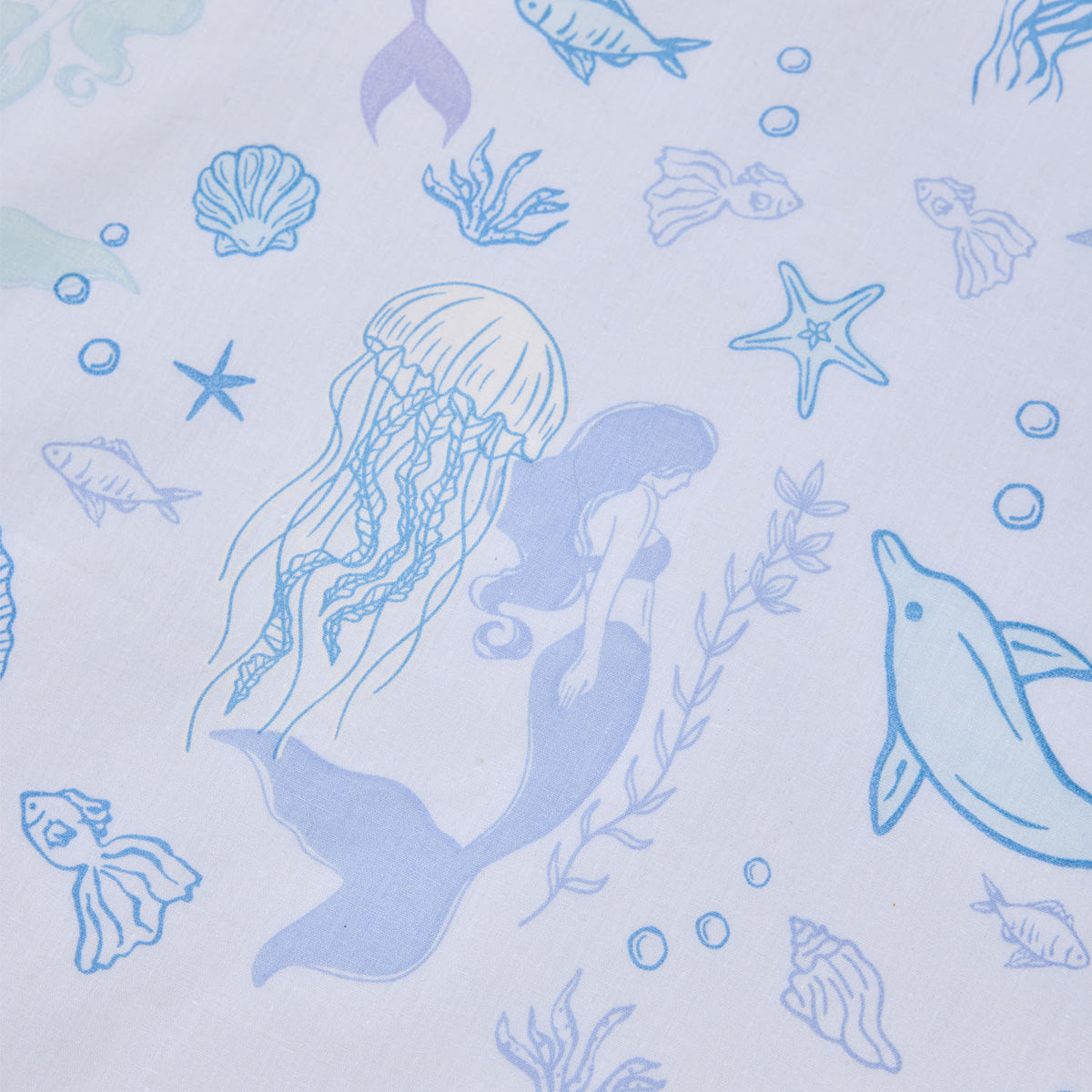 Close-up of the Mermaid Dreams fabric print featuring mermaids, jellyfish, dolphins, fish, shells, starfish and bubbles in blue and purple tones.