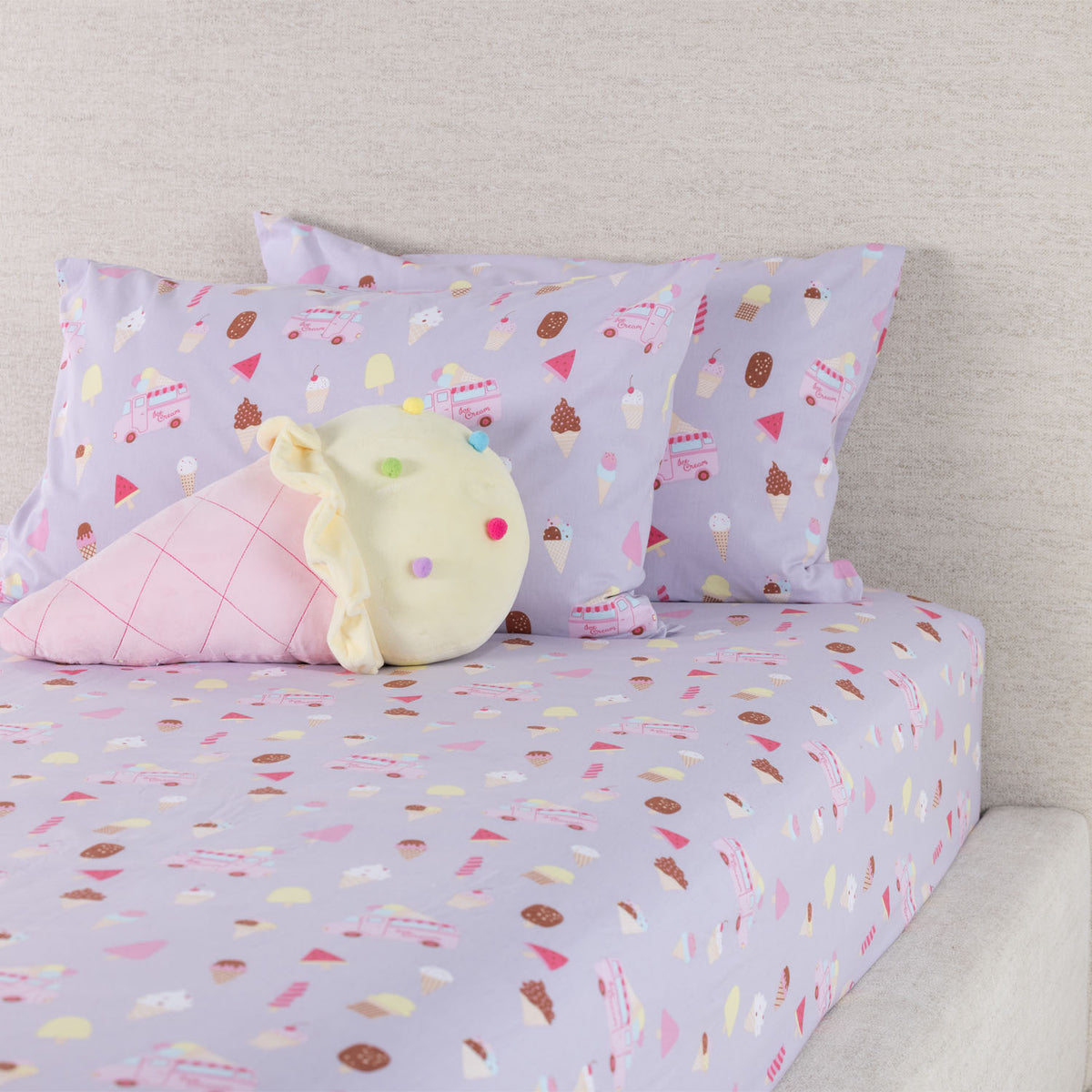 Ice Cream Shop fitted sheet set styled on a bed with matching printed pillowcases and a plush ice cream cone cushion.