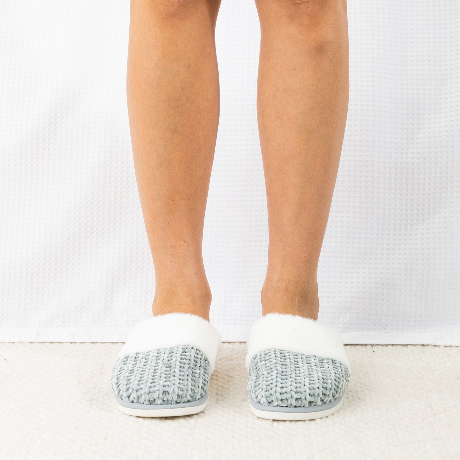 Person wearing Solace Chenille Faux Fur Trim Slippers in Sea Mist, featuring a soft chenille upper with plush white faux fur trim.