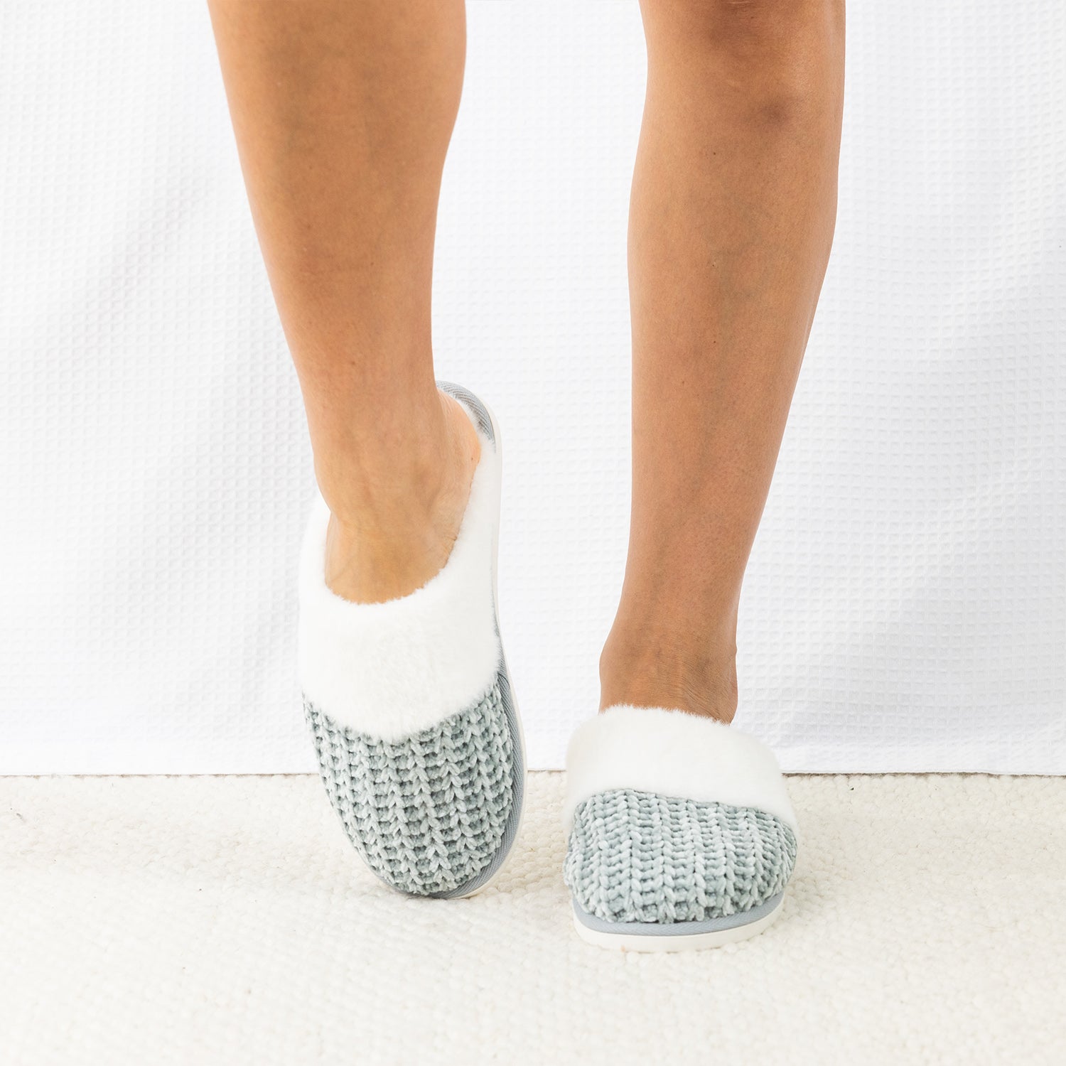 Person wearing Solace Chenille Faux Fur Trim Slippers in Sea Mist, featuring a soft chenille upper with plush white faux fur trim.