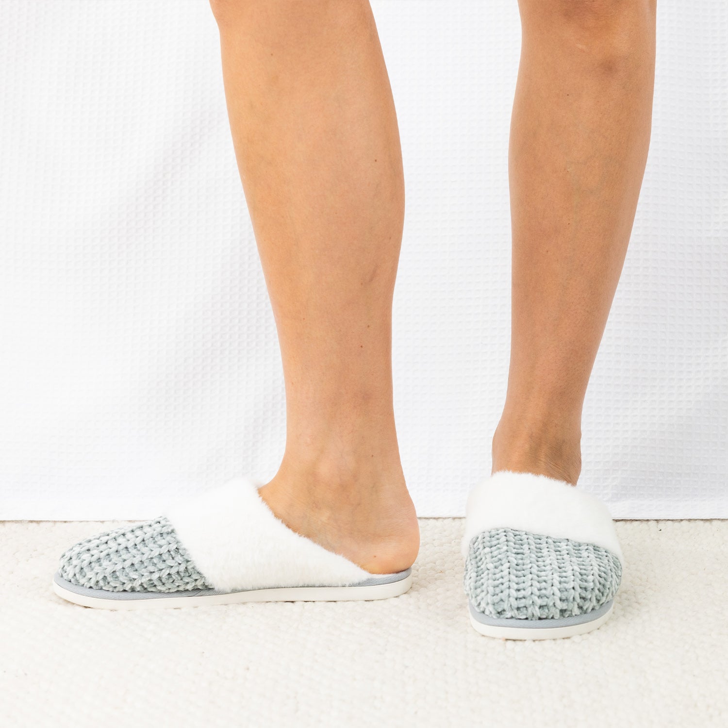 Person wearing Solace Chenille Faux Fur Trim Slippers in Sea Mist, featuring a soft chenille upper with plush white faux fur trim.