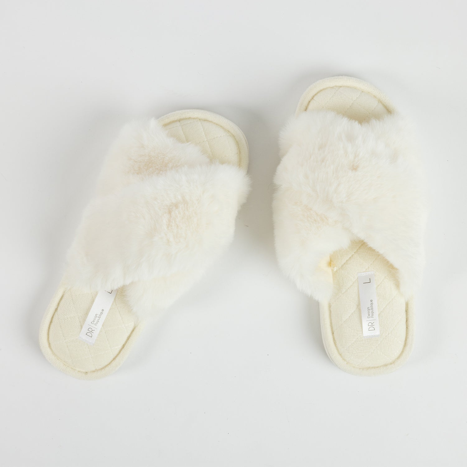 Pair of Design Republique Katie crossover slippers in Ivory, featuring a plush faux fur crossover upper and a soft quilted footbed, shown from a top-down view.