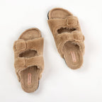 Pair of beige fuzzy slippers on a white background