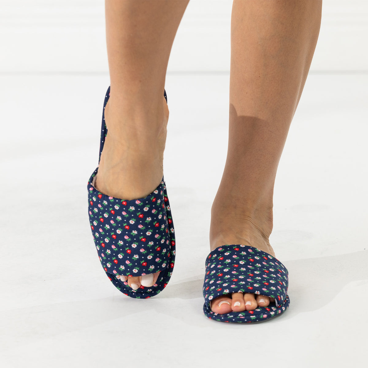 Navy floral open-toe slippers shown being worn from the front.