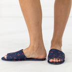 Solace Gracie Quilted Slippers Navy with a red cherry print, shown worn from the side.