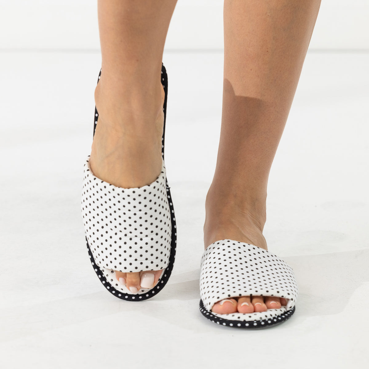 Solace Gracie Quilted Slippers White featuring a black polka dot print, shown worn from an angled view.