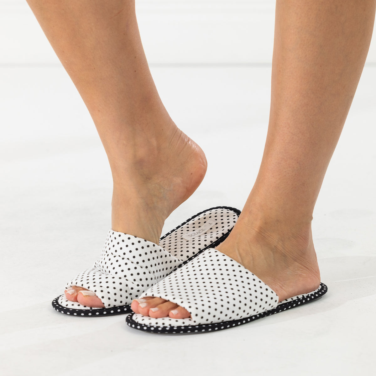 Solace Gracie Quilted Slippers White featuring a black polka dot print, shown worn from the front.