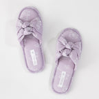Pair of lavender floral slippers on a light gray background