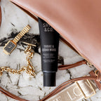 Smith & Co. Tabac & Cedarwood Hand & Nail Pomade 80ml nestled beside a tan leather handbag, gold jewellery and a watch on a marble surface.