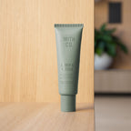 Smith & Co. Amber & Freesia Hand & Nail Pomade 80ml standing on a light wooden shelf with a softly blurred background.