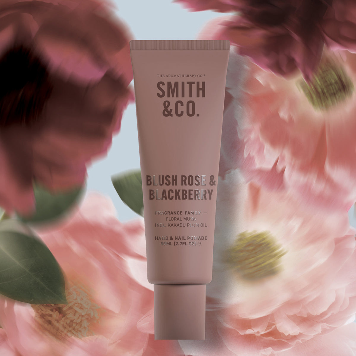 Smith & Co. Blush Rose & Blackberry Hand & Nail Pomade 80ml in a dusty pink tube surrounded by soft pink flowers.