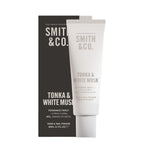 Smith & Co. Tonka & White Musk hand and nail pomade shown in a white squeeze tube with a dark charcoal box behind it on a white background.