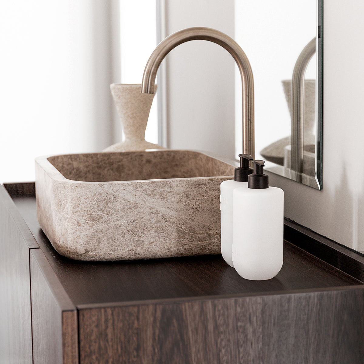 Two Smith & Co. Tonka & White Musk white pump bottles positioned beside a natural stone basin on a dark timber bathroom vanity.